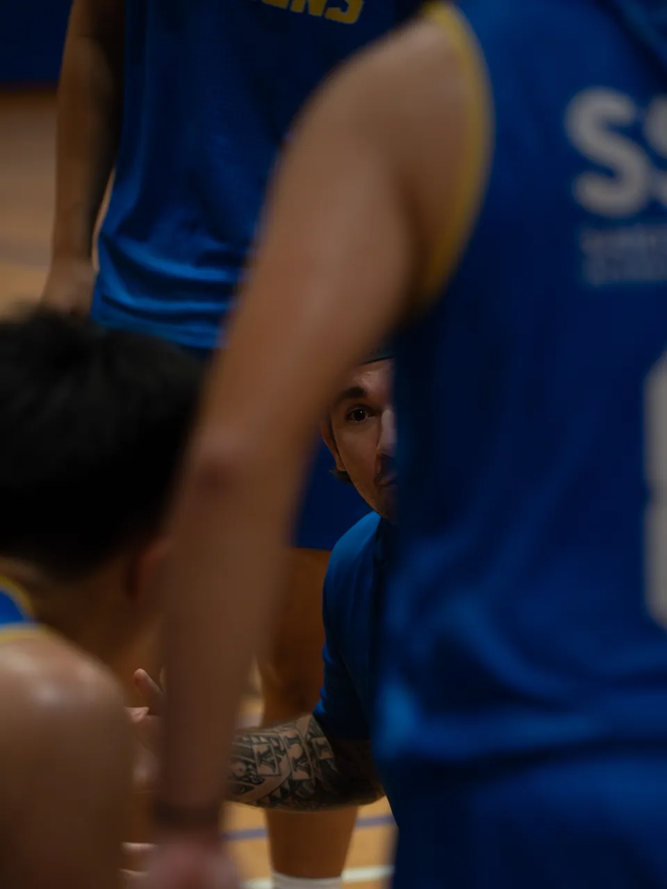Close crop of players contesting beneath the basket