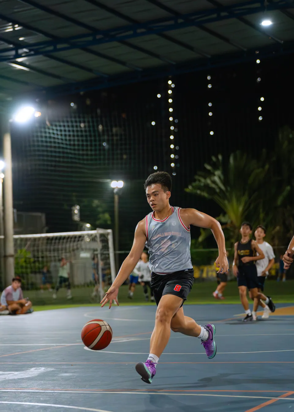 Outdoor basketball under floodlights at night
