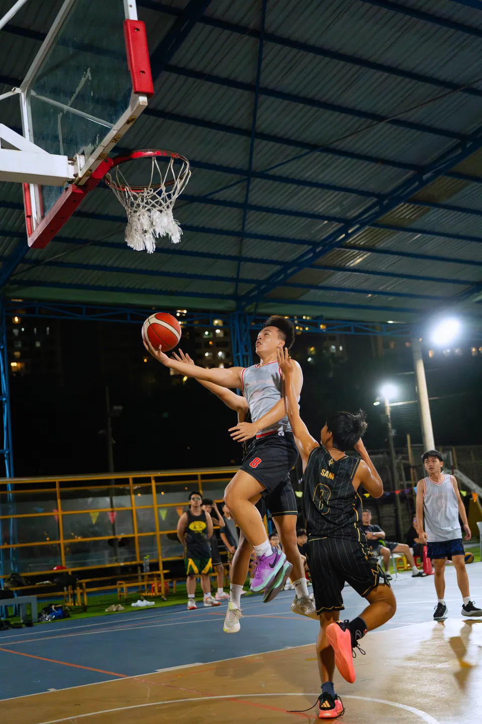Outdoor basketball under floodlights at night