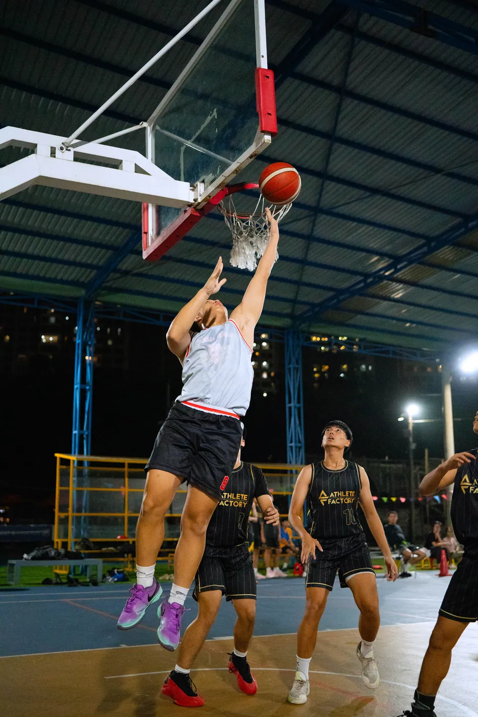 Outdoor basketball under floodlights at night