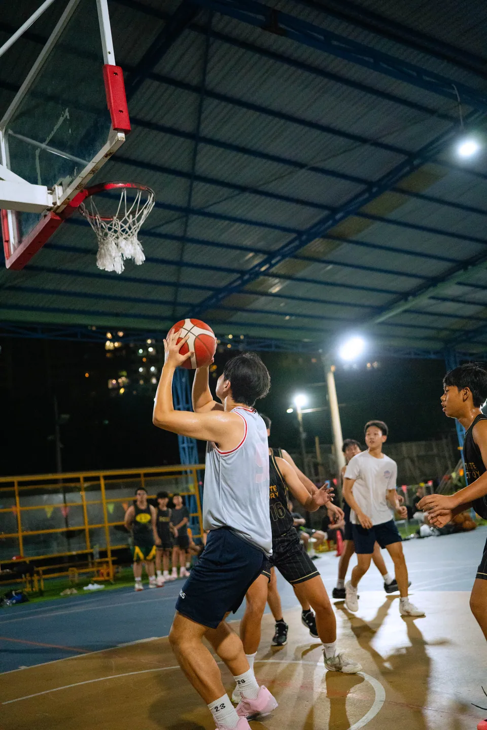 Outdoor basketball under floodlights at night