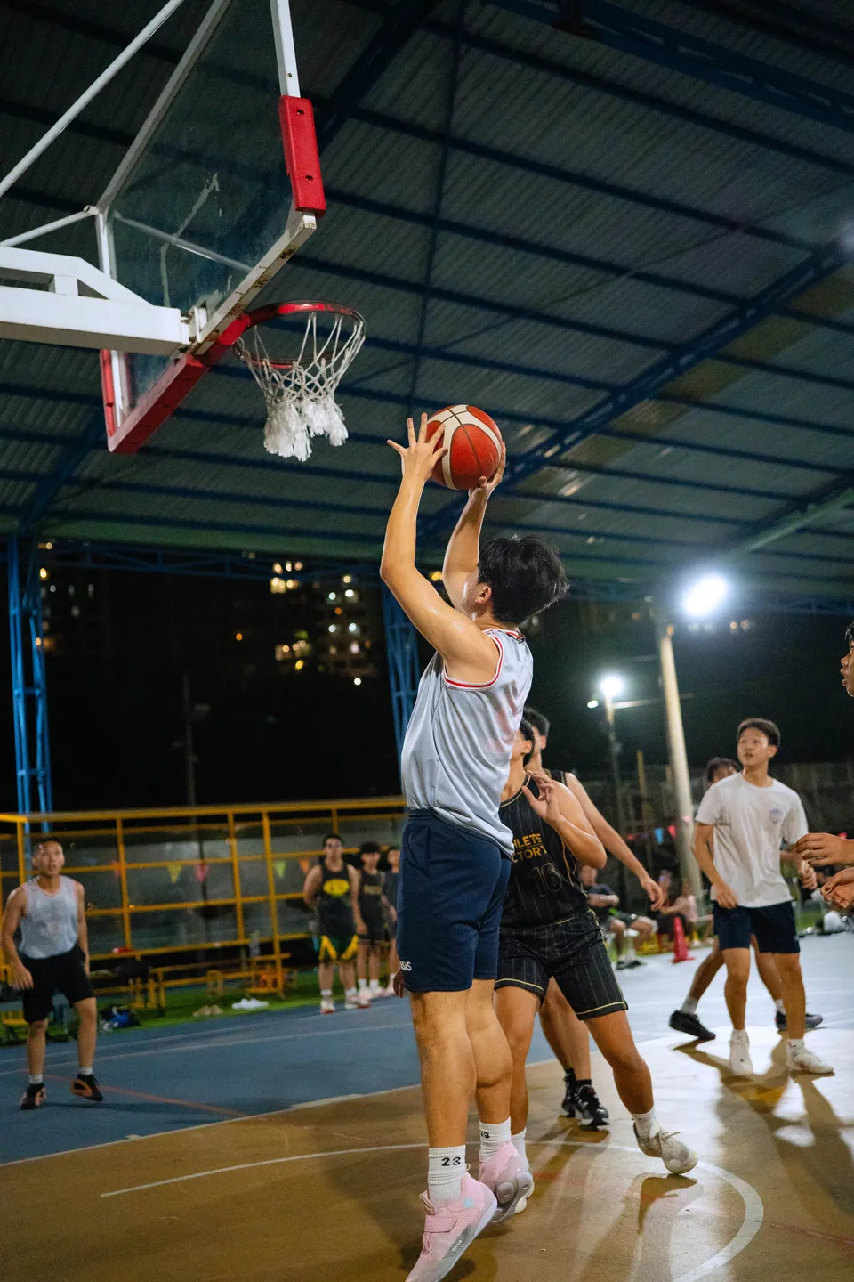 Outdoor basketball under floodlights at night