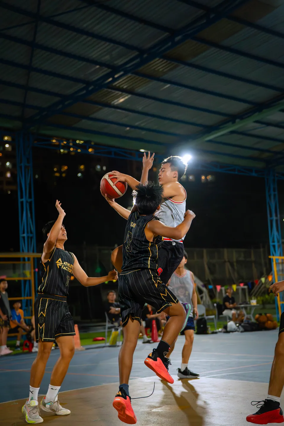 Outdoor basketball under floodlights at night