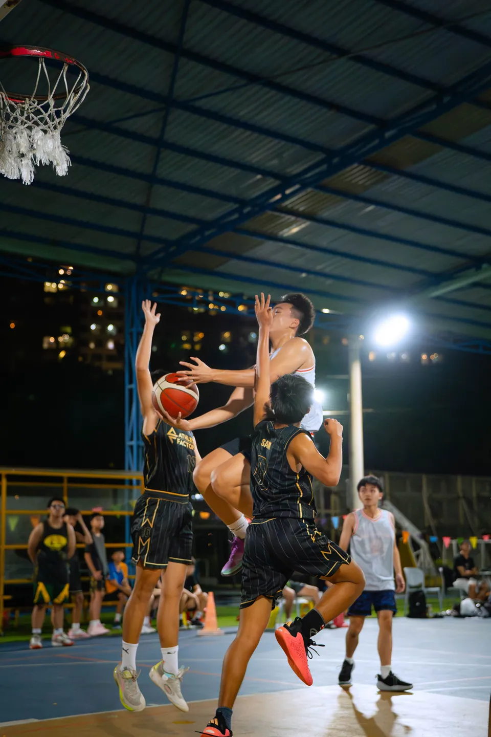 Outdoor basketball under floodlights at night