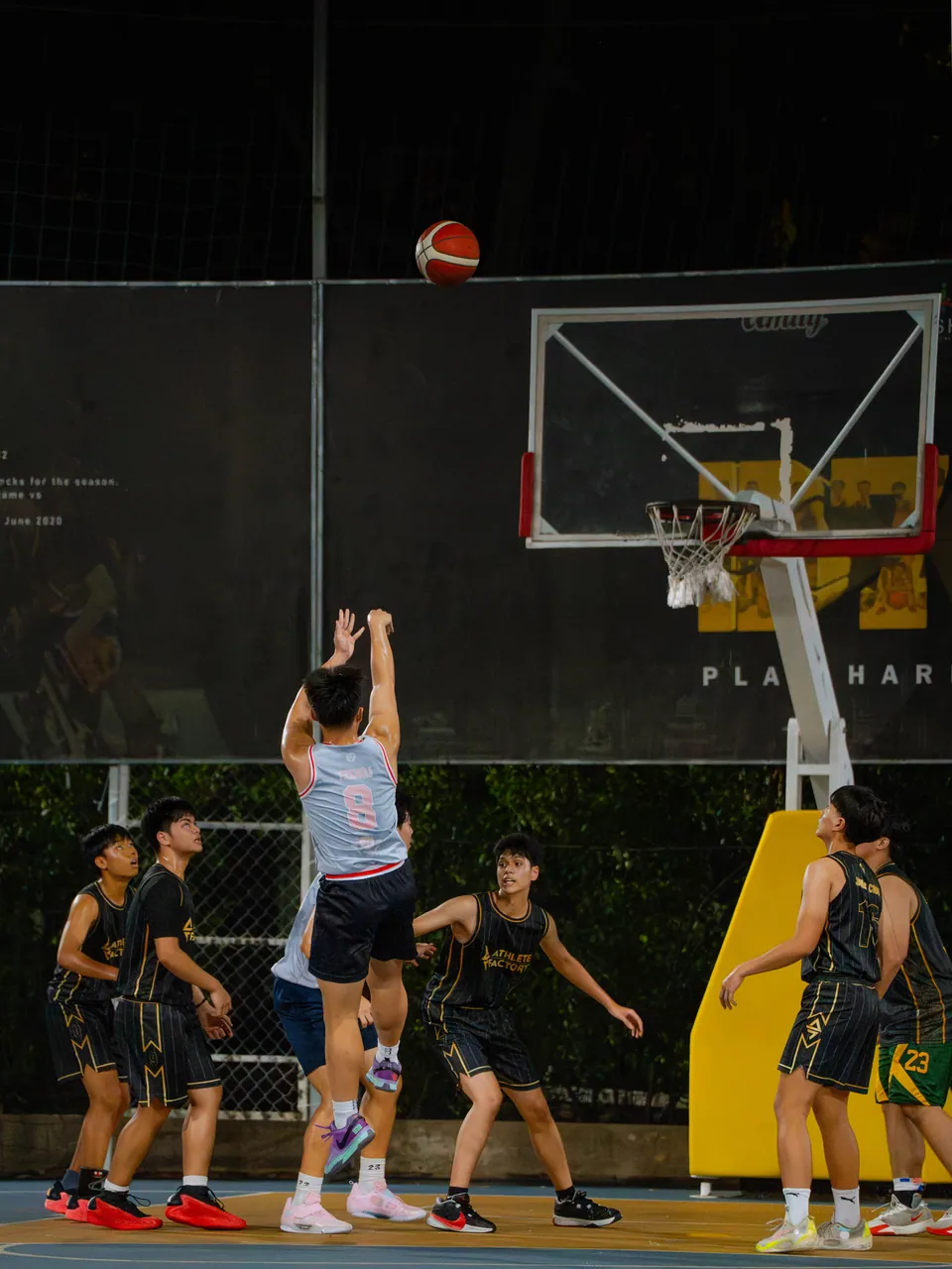 Outdoor basketball under floodlights at night