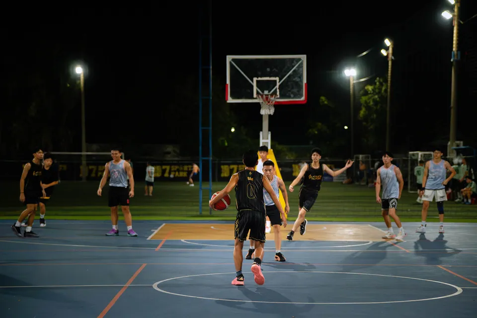 Outdoor basketball under floodlights at night