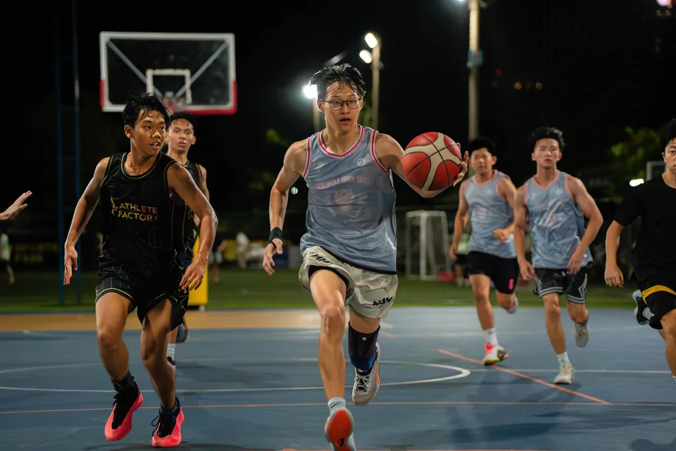 Players running the length of the court under floodlights