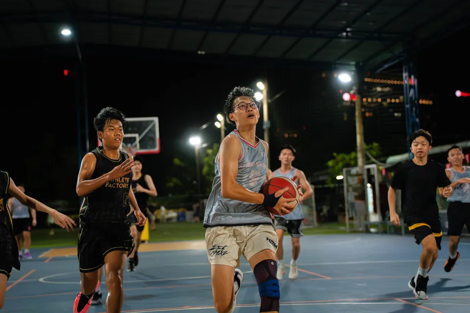 Outdoor basketball under floodlights at night