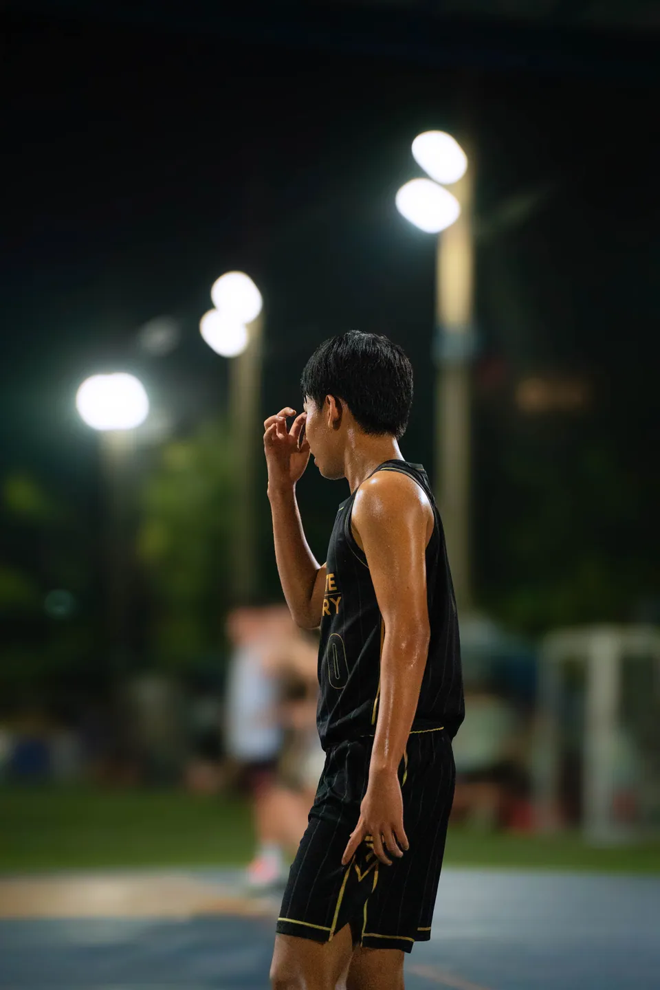 Player standing alone under floodlights