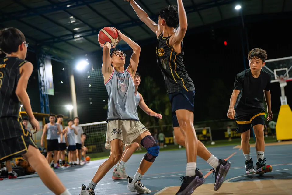 Outdoor basketball under floodlights at night